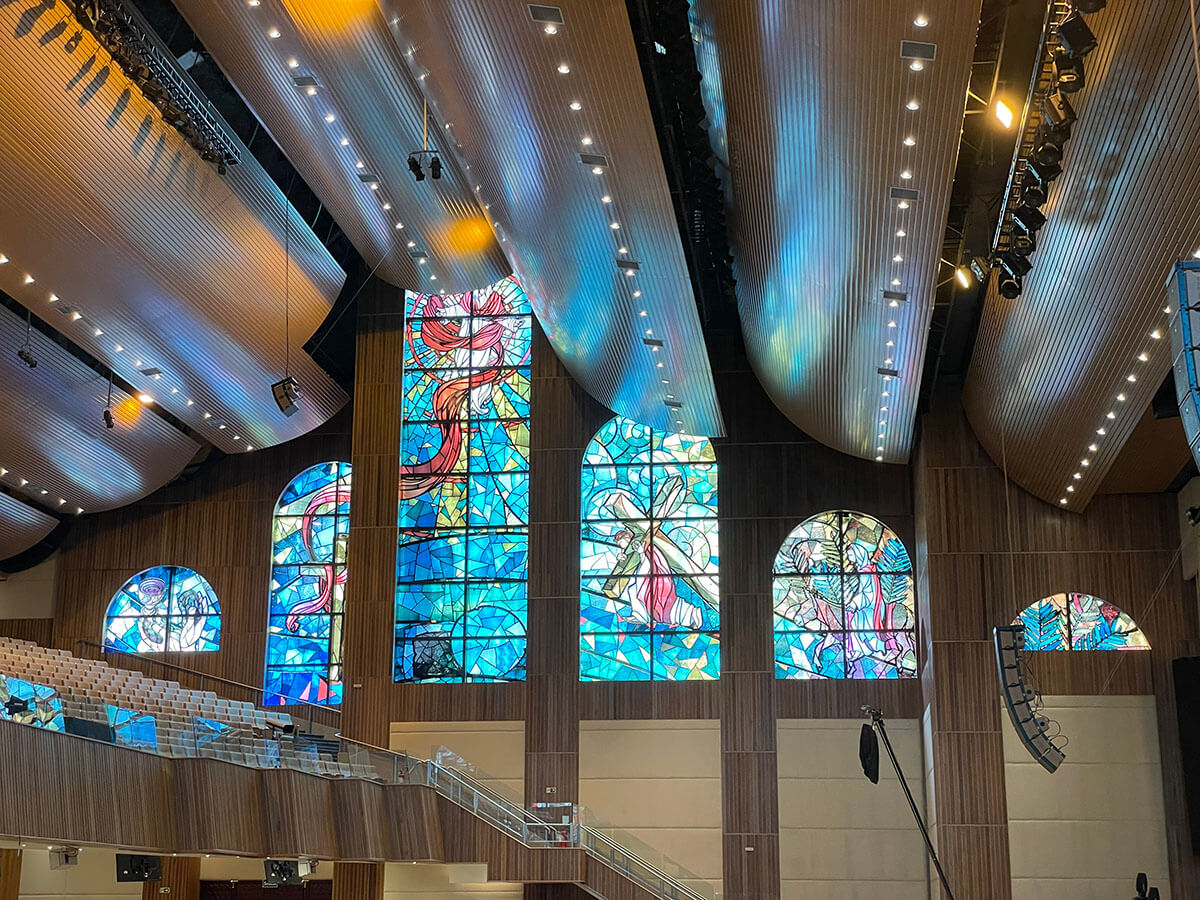 Interior de uma igreja batista com vitrais e forro acústico