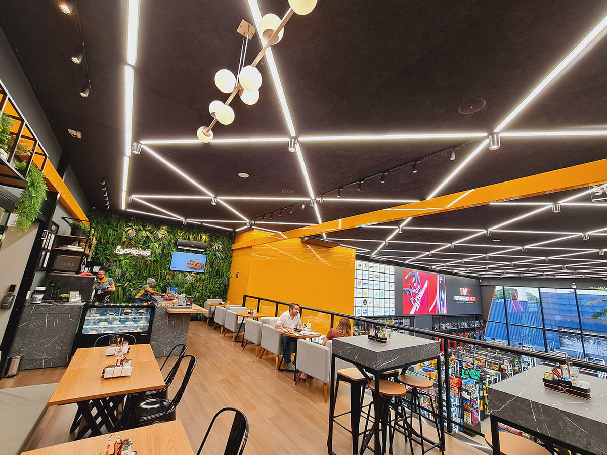 Interior da Varejocar, um ambiente comercial com café e forros acústicos da Garbe