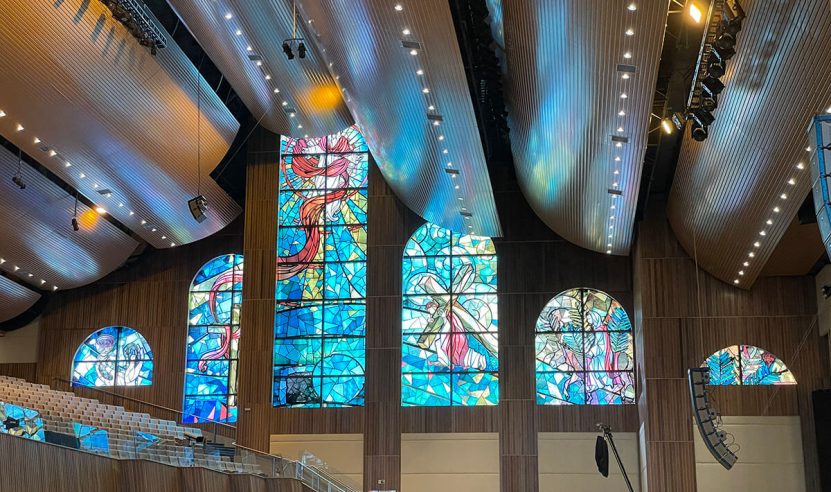 Interior de uma igreja batista com vitrais e forro acústico