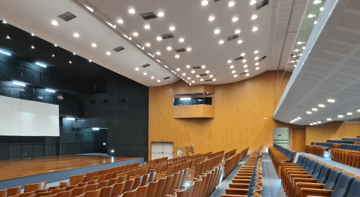 A escolha do Fibracitex para revestir as paredes do auditório da USP, em São Paulo, foi fundamental para a melhoria da acústica do local. Esse revestimento de fibra de madeira mineralizada apresenta características excepcionais, como alta resistência e durabilidade, sendo perfeito para ambientes que demandam foco na palavra falada, como auditórios. O Fibracitex oferece excelente absorção acústica, contribuindo para a clareza do som e proporcionando um ambiente mais agradável aos ouvintes. Além disso, o material é incombustível e térmico, garantindo segurança e conforto. Com diferentes modulações e espessuras disponíveis, o Fibracitex possibilita soluções técnicas eficientes para atender às necessidades do projeto. Sua estética moderna e elegante complementa a arquitetura do auditório da USP, agregando valor estético ao ambiente.
