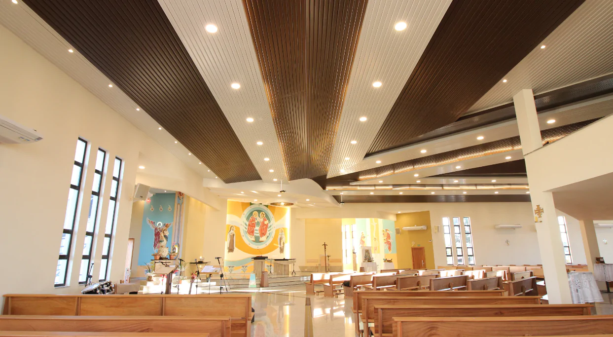 Na Paróquia Nossa Senhora das Vitórias, em Curitiba/PR, o Metalfort foi escolhido para aprimorar tanto a estética quanto a acústica do ambiente. Esse revestimento metálico de alumínio foi especialmente projetado para elevar de forma expressiva a inteligibilidade da fala, o que é essencial em espaços que valorizam a palavra falada, como as igrejas. Com sua ampla variedade de opções de paginação e fabricação, o Metalfort oferece soluções técnicas eficientes para atender às necessidades acústicas específicas da Paróquia Nossa Senhora das Vitórias. Além de sua função acústica, o Metalfort apresenta um design moderno e sofisticado, projetado para se assemelhar à beleza natural da madeira. Com sua durabilidade, resistência ao fogo, imunidade a pragas e propriedades térmicas, o Metalfort oferece um ambiente harmonioso e acusticamente agradável para os frequentadores da igreja.