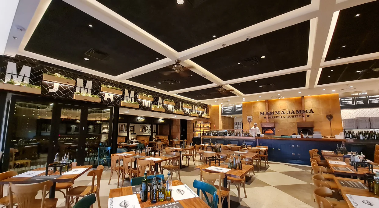 Localizado em Campinas/SP, o Restaurante Mamma destaca-se por sua dedicação em proporcionar a melhor experiência aos clientes. Com o compromisso de criar um ambiente acolhedor e agradável, o restaurante optou pela instalação do Forrofort, uma escolha que reflete sua atenção aos detalhes. O Forrofort é conhecido por sua resistência e estética atraente, adicionando um toque de elegância e sofisticação ao ambiente do restaurante. Fabricado com fibra de madeira mineralizada, esse material garante uma durabilidade excepcional, mantendo o espaço atraente por muitos anos. Além de sua aparência agradável, o Forrofort possui excelentes propriedades acústicas, o que é essencial em um restaurante. Com a redução significativa dos níveis de ruído proporcionada pelo Forrofort, o Restaurante Mamma Jamma cria um ambiente mais tranquilo e relaxante para seus clientes aproveitarem. Outra vantagem do Forrofort é sua incombustibilidade, aumentando a segurança do local. Além disso, suas propriedades térmicas contribuem para manter uma temperatura confortável no restaurante, independentemente das condições climáticas externas. Com a capacidade de personalização do Forrofort, o Restaurante Mamma Jamma pôde adaptar o forro às suas necessidades específicas. O resultado é um espaço que reflete a identidade única do restaurante e oferece uma experiência confortável e excepcional para os clientes. A escolha do Forrofort pelo Restaurante Mamma Jamma demonstra seu compromisso em fornecer a melhor experiência aos clientes. Essa decisão ressalta o impacto positivo que a escolha certa de materiais pode ter na atmosfera e na experiência geral de um restaurante, proporcionando um ambiente acolhedor e sofisticado para todos desfrutarem.